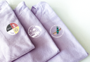 Purple fabric with embroidered logos on a white background