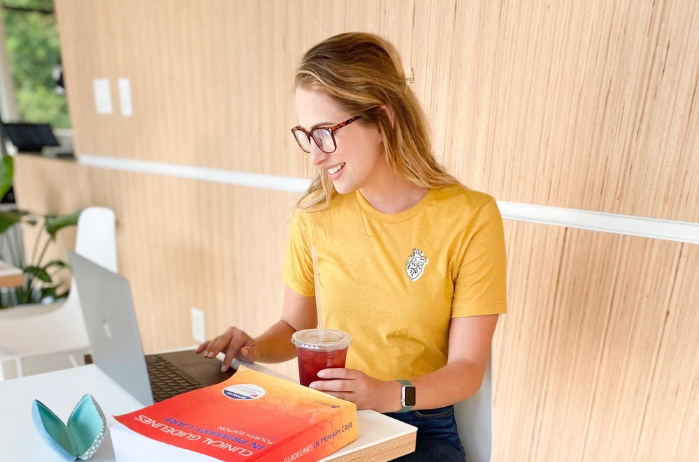 Nurse sitting on chair, clicking through a laptop