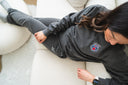 Woman sitting on couch lounging in a sweatsuit