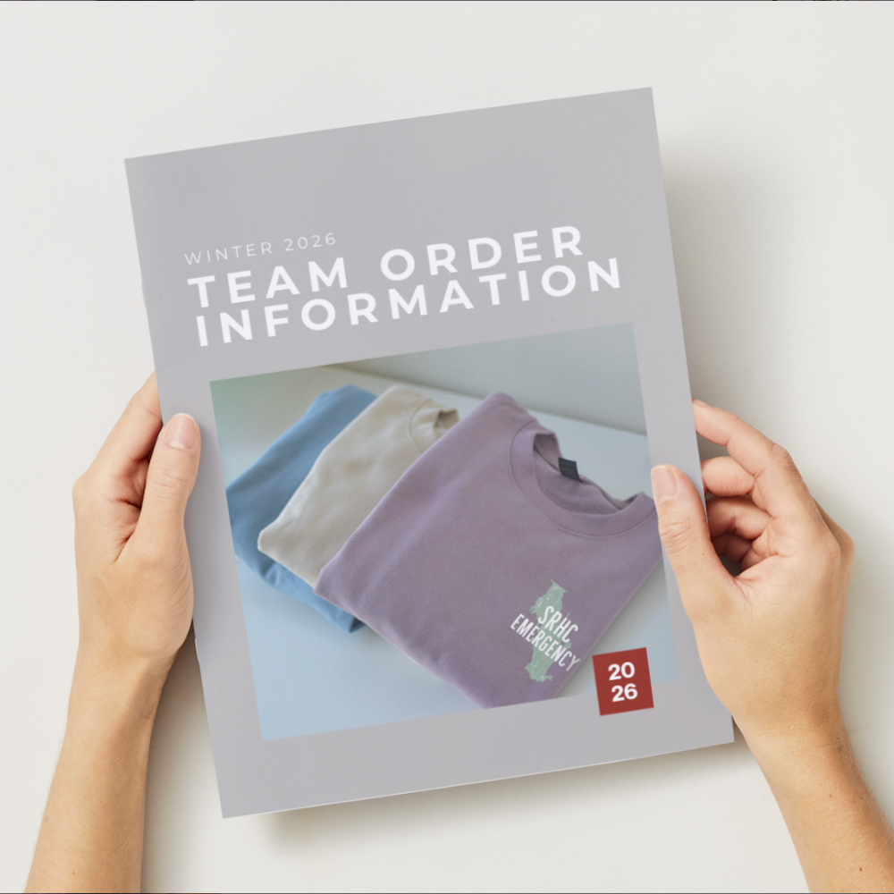 Person holding a 'Team Order Information' booklet with images of shirts on a white background